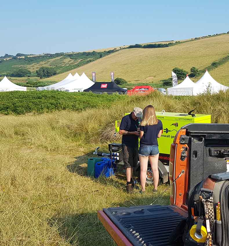 Georgia and Paul setting up generator hire in a field